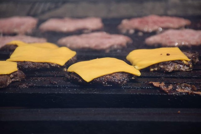 cheeseburgers cooking on grill