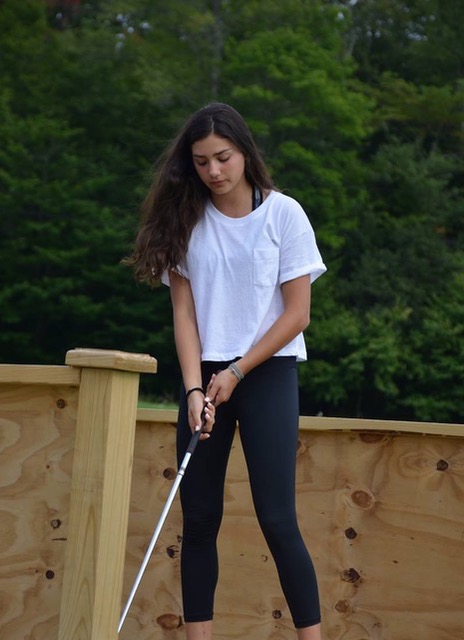 girl swinging golf club