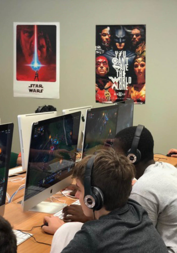 Two boys playing on the computer next to each other