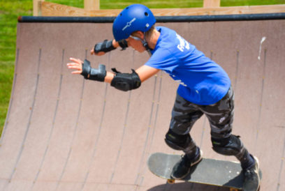Camper riding down the half pipe on a skateboard