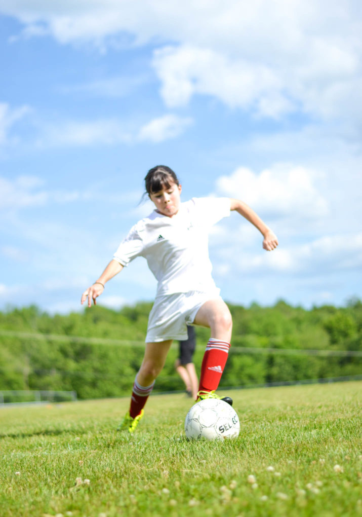 Camper about to kick a soccer ball