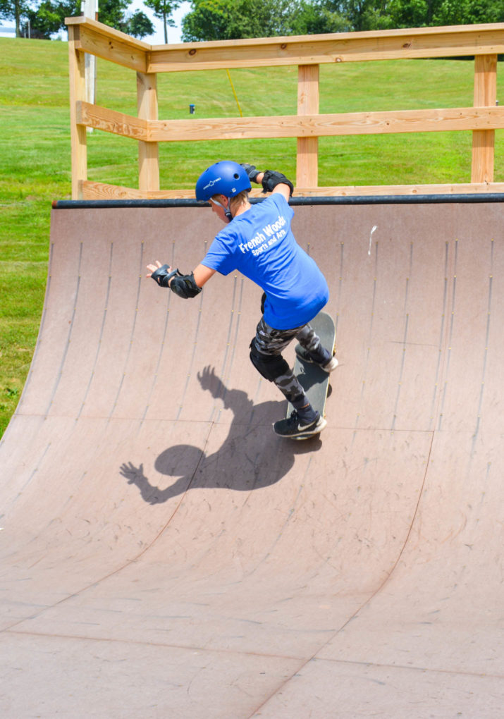 Camper riding down the half pipe on a skateboard