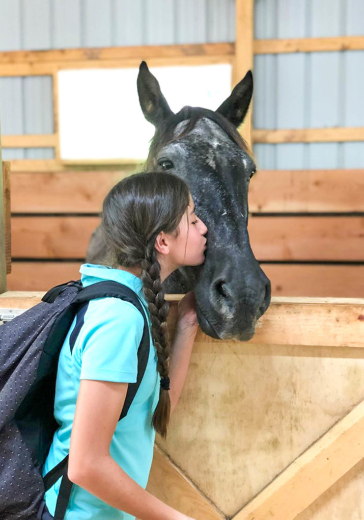 Camper giving a horse a kiss