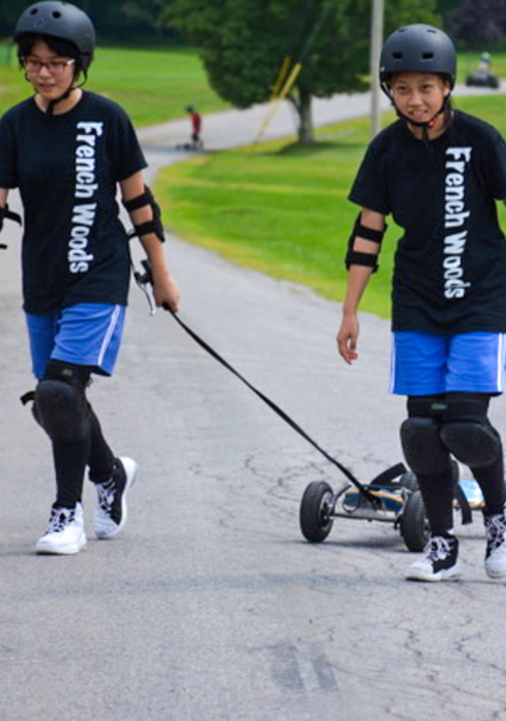 Two campers walking with their boards