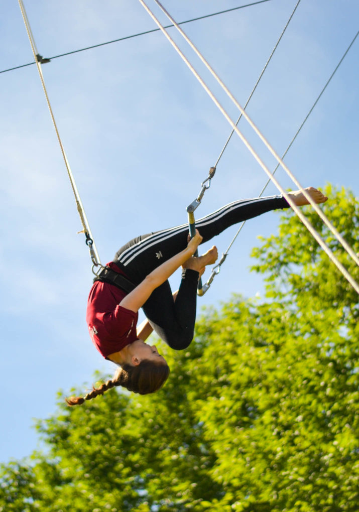 Camper doing a trapeze stunt