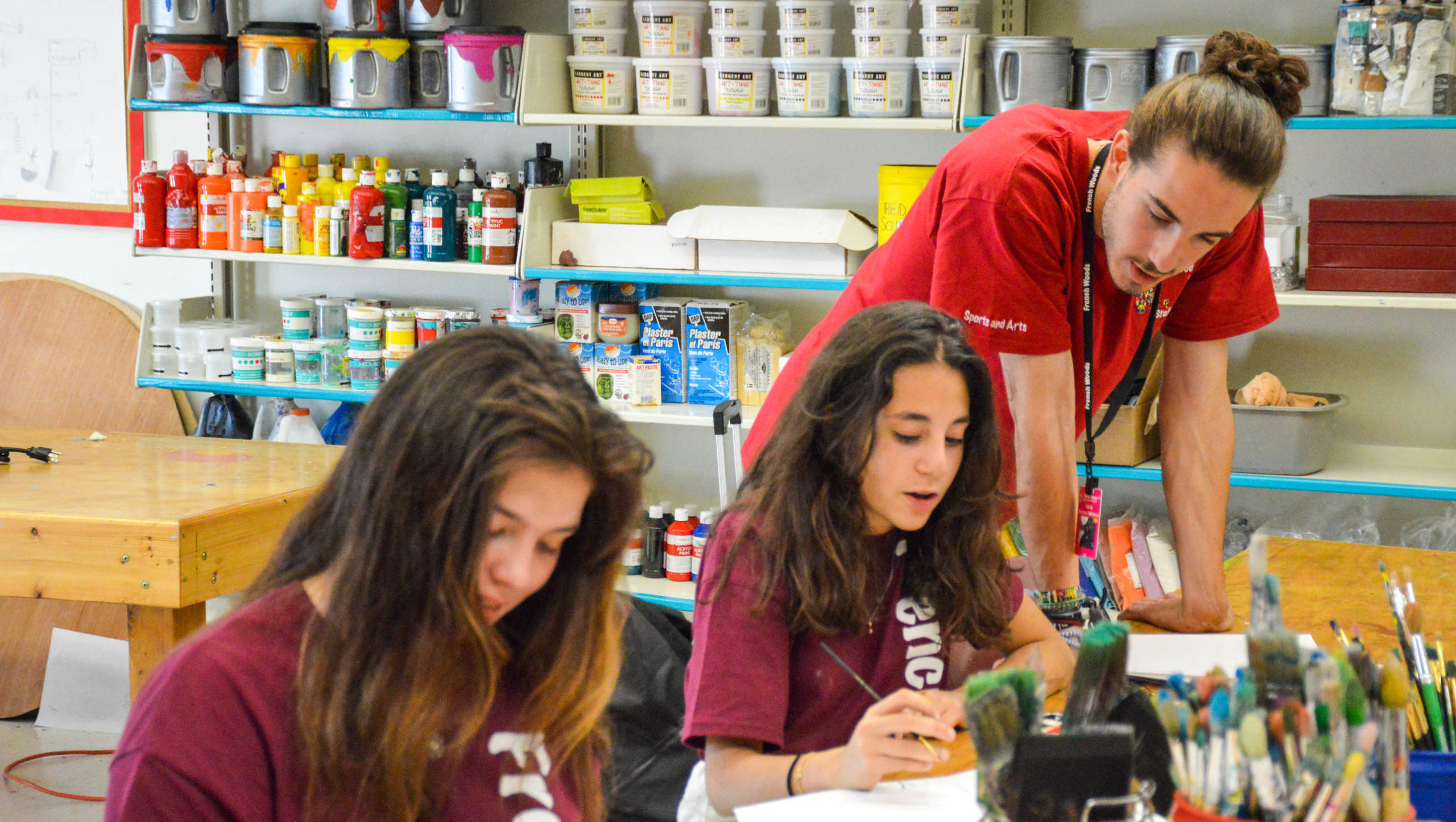 Staff member helping campers with an art project