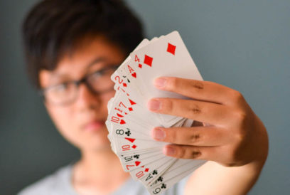 Camper holding up playing cards