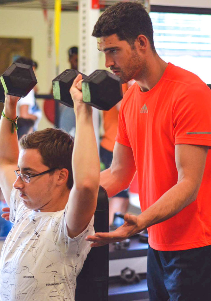 Boy weight training with a coach