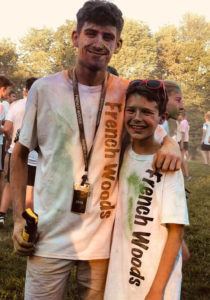 Counselor and camper with shirts covered in colorful chalk