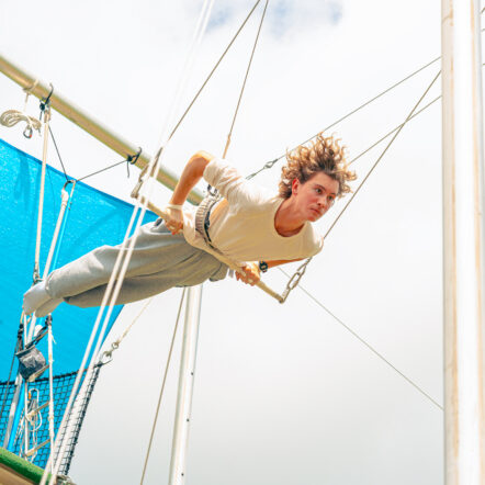 A teen boy on the flying trapeze at summer camp