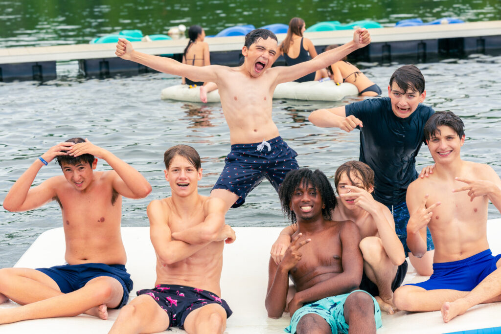 A group of teenage boys playing in the lake at a teen only summer camp
