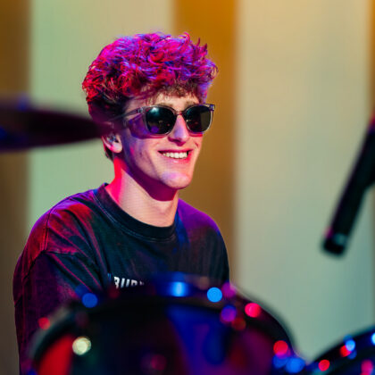 Teen boy playing the drums on stage at summer camp