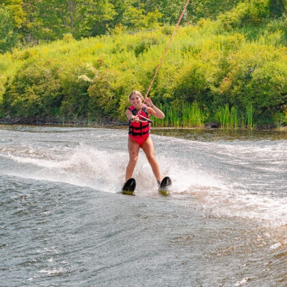 Teen girl water skiing on the lake at summer camp