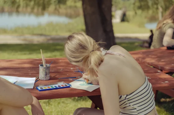 A teen camper creating artwork during Painting by the Pond at New York Teen Camp